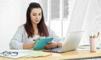 Young illustrator draws on a tablet at work. Concept for business, work, career. Young illustrator draws on a tablet at work. Concept for business, work, career and success.